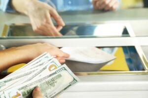 Female hand with money in cash department window. Currency exchange concept Partner Store in Brisbane