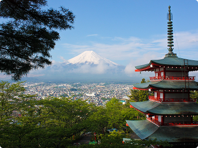 <span>Travel</span> card in <span>Japan</span> A red pagoda stands amid green trees in Japan, with Mount Fuji in the background under a clear blue sky.