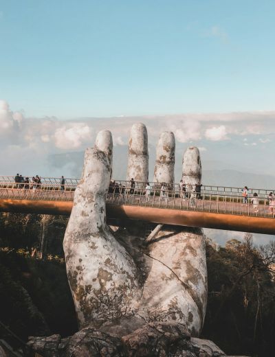 <span>Virtual cards</span> for online and in-store use A large stone hand sculpture supports a pedestrian bridge in Vietnam, with people walking across it, set against a backdrop of sky and mountains.
